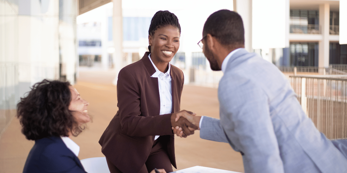 Woman giving man a handshake at 2Win's presales training for building their personal brand